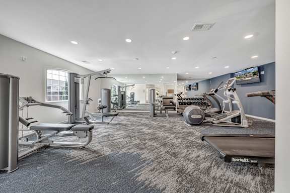 A spacious gym with a variety of equipment including treadmills, stationary bikes, and weight machines. at Sunscape Apartments, Virginia, 24018