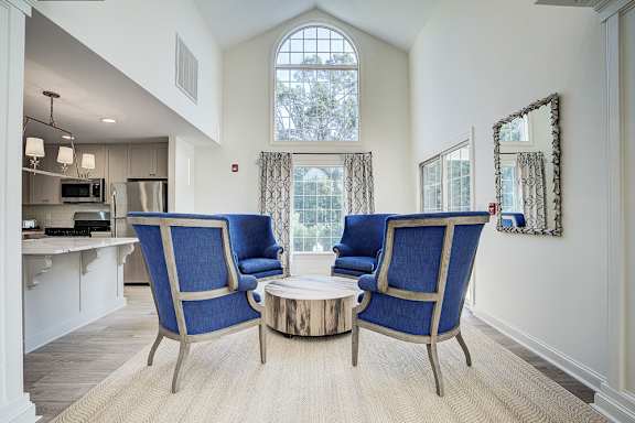 A living room with a blue chair and a coffee table. at Sunscape Apartments, Virginia, 24018