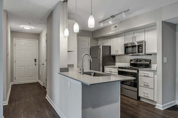 A modern kitchen with a large island and stainless steel appliances. at Sunscape Apartments, Roanoke