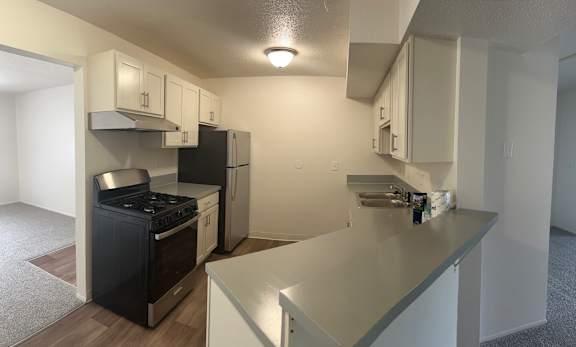 A kitchen with black appliances and white cabinets