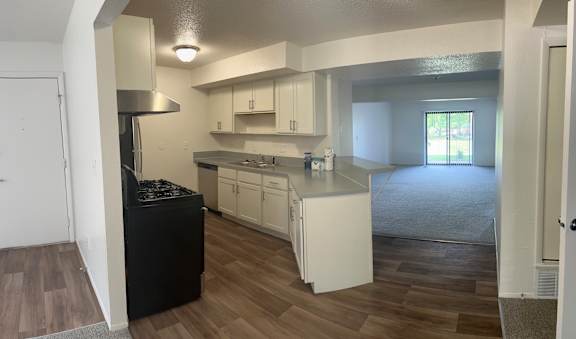 A kitchen with white cabinets and a black island