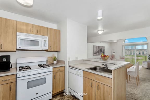 a kitchen with a gas stove, microwave and a dishwasher at Tall Oaks Apartment Homes, Kalamazoo, Michigan