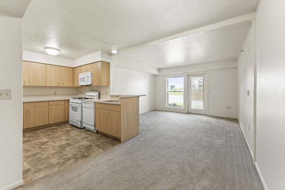 A kitchen with wooden cabinets and a white dishwasher at Tall Oaks Apartment Homes, Kalamazoo, MI, 49009