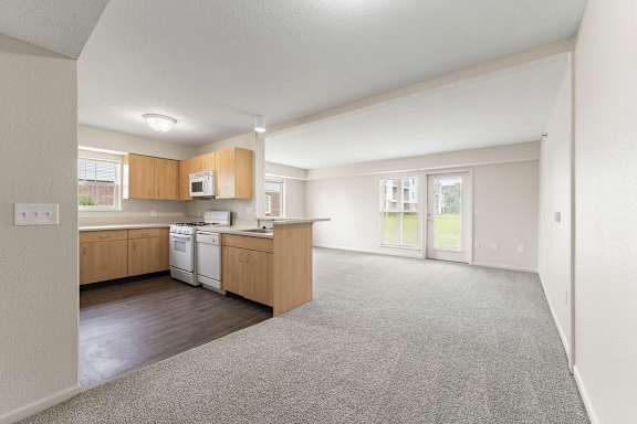 A spacious kitchen with wooden cabinets and a white dishwasher at Tall Oaks Apartment Homes, Kalamazoo, MI