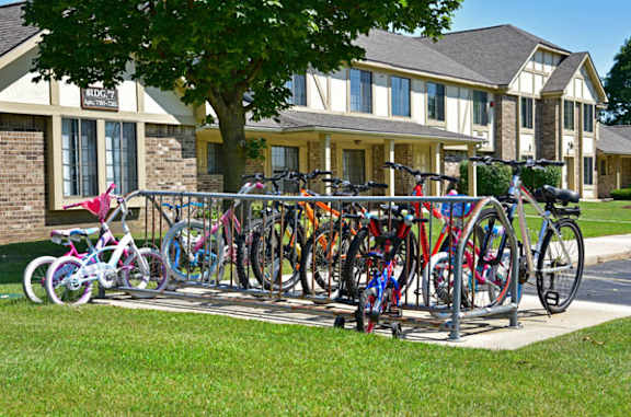 A row of bicycles are parked in front of a building at Tanglewood Apartments, Oak Creek, WI