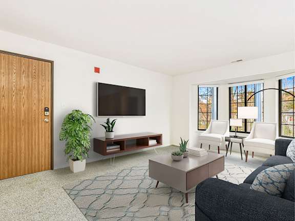 A living room with a bay window, a couch, and a rug  at Tanglewood Apartments, Oak Creek, WI