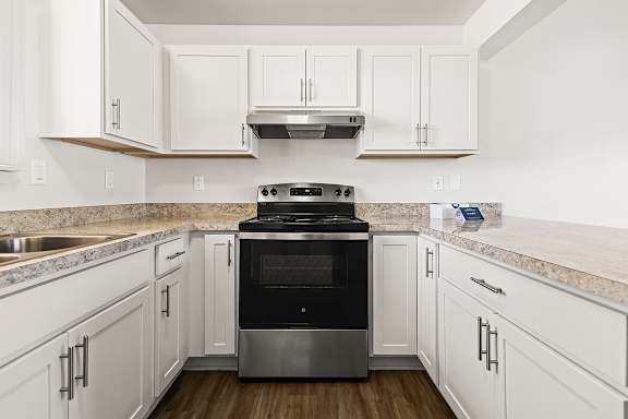 A modern kitchen with white cabinets and a stainless steel oven at Tanglewood Apartments, Oak Creek, WI