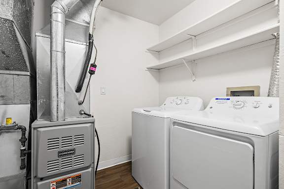 A full-size washing machine is in a laundry room with a dryer at Tanglewood Apartments, Oak Creek, WI
