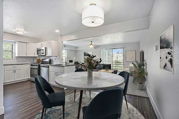 A modern kitchen with a dining table set for four at Byron Lakes Apartments in Byron Center, MI