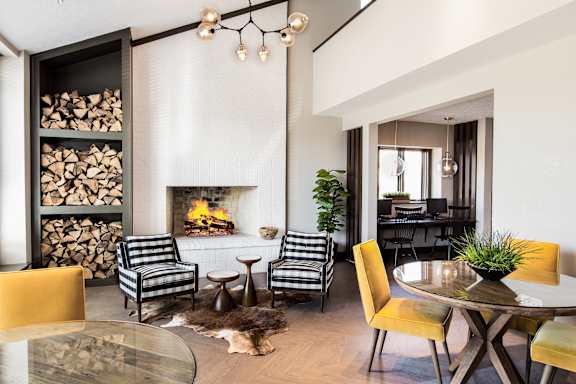 a living room with a fireplace and a table and chairs at The Timbers Apartments, Evansville