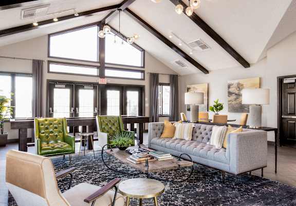 a living room with couches and chairs and a rug at The Timbers Apartments, Evansville