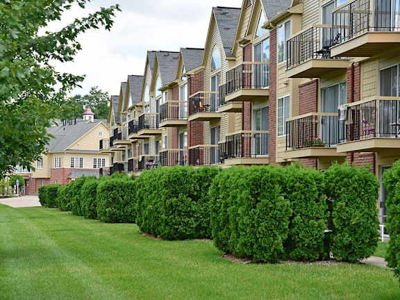 a row of bushes in front of an apartment building