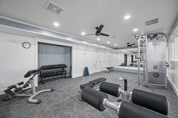 A gym with a variety of equipment including weights and a bench press