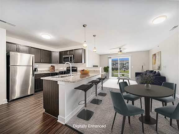 A kitchen with a refrigerator, a counter, and a dining table at Trade Winds Apartment Homes, Elkhorn, NE
