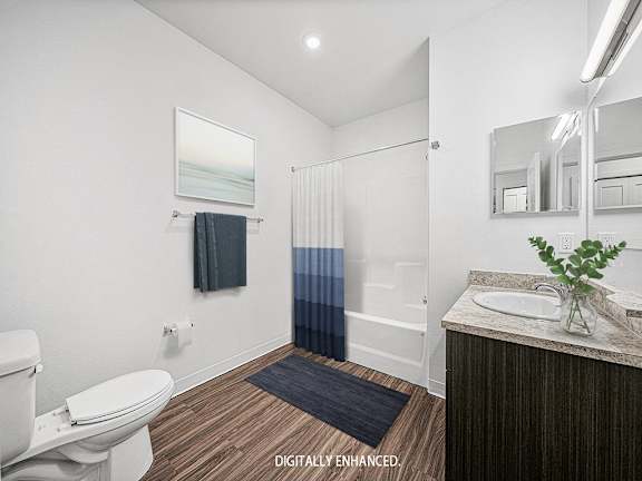 main bathroom with a toilet sink and a shower at Trade Winds Apartment Homes, Elkhorn, Nebraska