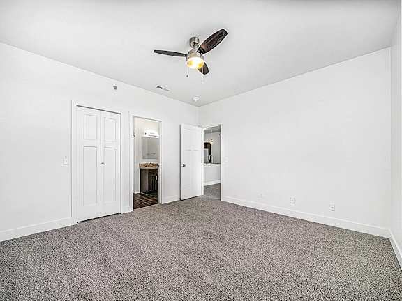 A bedroom with a ceiling fan and carpeted floor at Trade Winds Apartment Homes, Elkhorn, NE