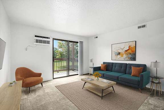 A living room with a blue couch, a brown chair, and a painting on the wall at Trappers Cove Apartments, Michigan, 48910