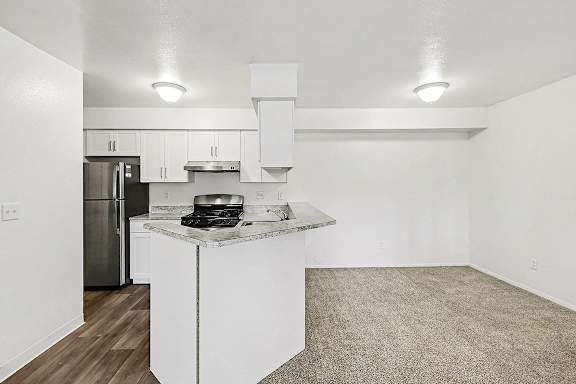 A kitchen with a breakfast bar and a dining room at Trappers Cove Apartments, Lansing