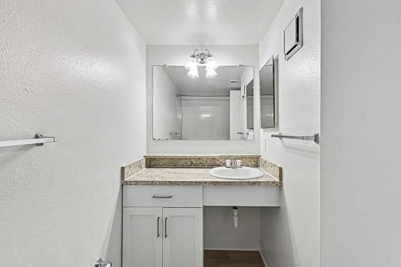 A bathroom with a sink and mirror at Trappers Cove Apartments, Lansing