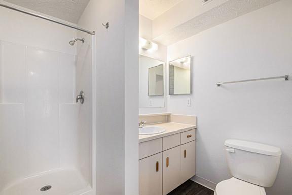 A white bathroom with a shower, toilet, and sink at Trillium Pointe Apartment Homes, Michigan, 49201