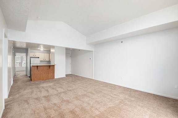 A large empty dining room with a kitchen area in the background at Trillium Pointe Apartment Homes, Michigan, 49201