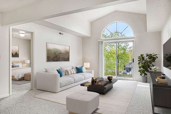 A living room with a cathedral ceiling and large window at Trillium Pointe Apartment Homes, Jackson, MI