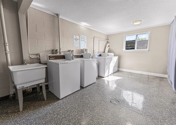 A kitchen with a dishwasher, sink, and a window
