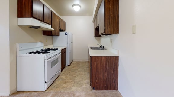 a kitchen with a stove refrigerator and a sink at Walnut Trail Apartments, Portage, MI