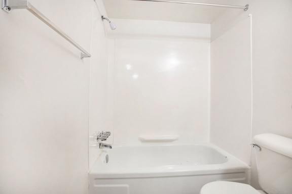 Bathroom with tub shower combo and white fixtures at Walnut Trail Apartments, Michigan
