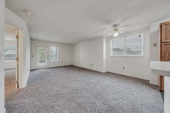 A spacious room with a ceiling fan and carpeted floor at WaterFront Apartments, Virginia Beach