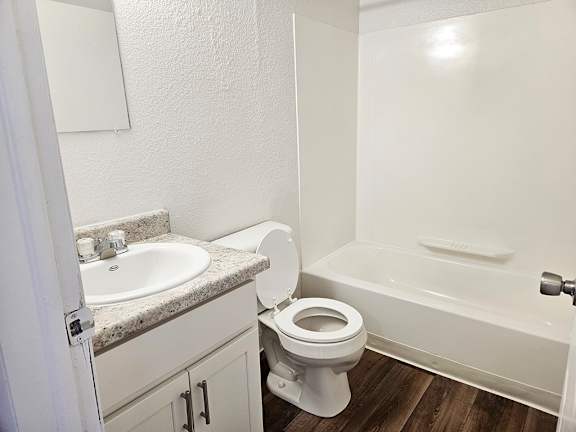 A bathroom with a toilet and a bathtub at Waverly Park Apartments, Lansing