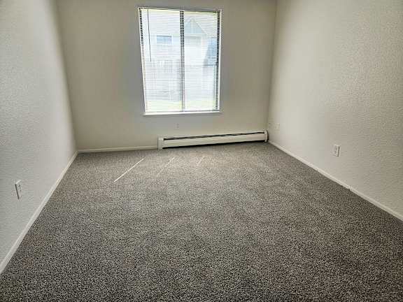 A bedroom with a window and plush carpet at Waverly Park Apartments, Lansing