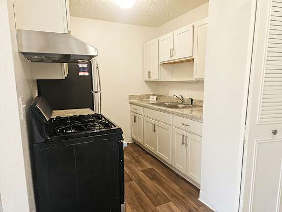 A stainless steel stove in a kitchen with white cabinets at Waverly Park Apartments, Lansing