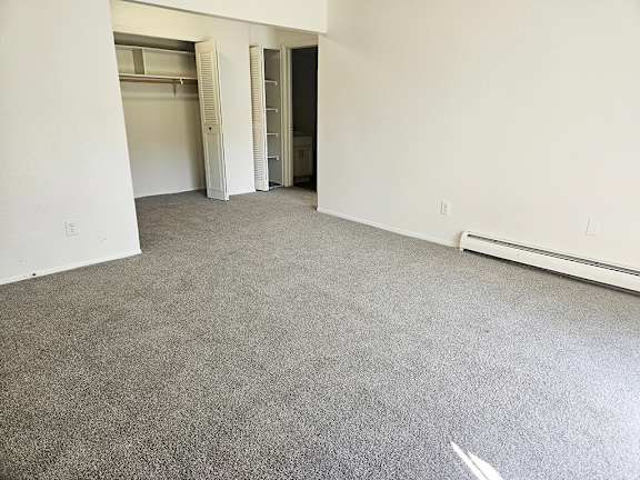 A dining room with a grey carpet and a closet at Waverly Park Apartments, Lansing