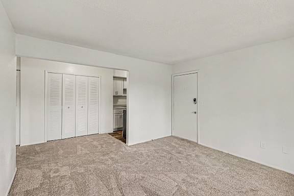 A dining room with a carpeted floor and white walls at Waverly Park Apartments, Lansing, Michigan