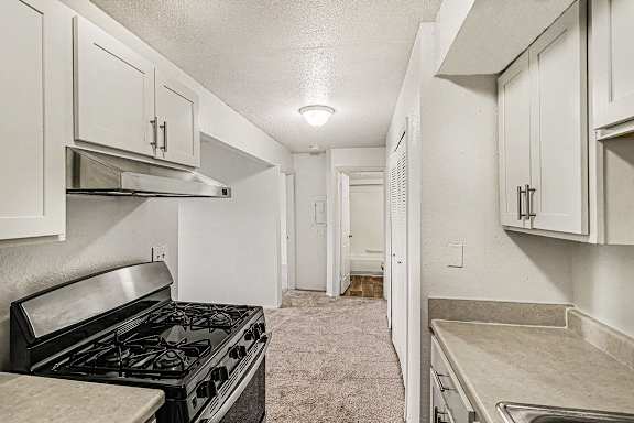 A kitchen with white cabinets and a stainless steel appliances at Waverly Park Apartments, Lansing, Michigan