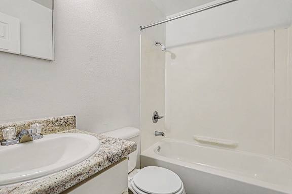 A bathroom with a bathtub, sink, and toilet at Waverly Park Apartments, Lansing, Michigan