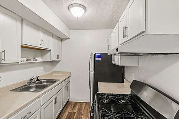A kitchen with white cabinets and stainless steel appliances at Waverly Park Apartments, Lansing, MI