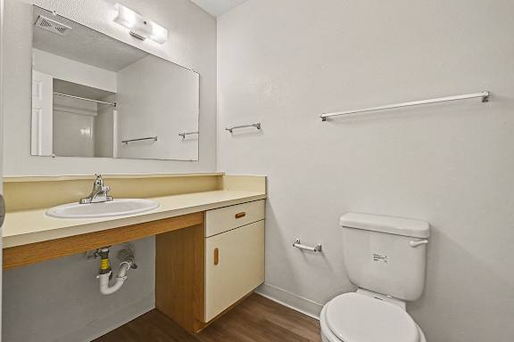 A toilet with a sink and a wooden counter  at West Hampton Park Apartment Homes, Nebraska, 68022