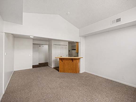 A dining room with a carpeted floor and a breakfast bar  at West Hampton Park Apartment Homes, Nebraska, 68022