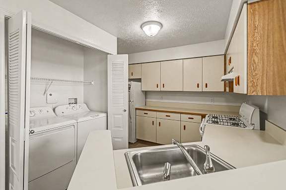 A  clean kitchen with a washer and dryer at West Hampton Park Apartment Homes, Nebraska, 68022