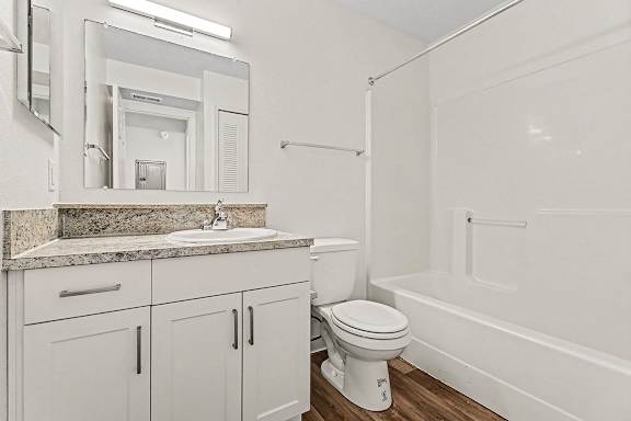 A white bathroom with a sink, toilet, and bathtub at West Hampton Park Apartment Homes, Nebraska, 68022
