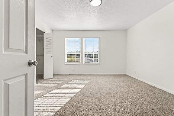 A bedroom with a carpeted floor and a window  at West Hampton Park Apartment Homes, Nebraska, 68022