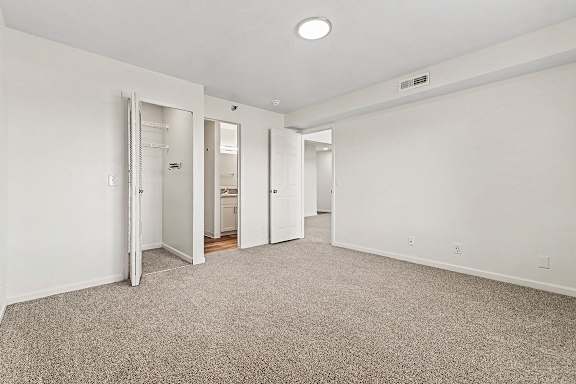 A bedroom with a carpeted floor and a walk-in closet and ensuite bathroom  at West Hampton Park Apartment Homes, Nebraska, 68022