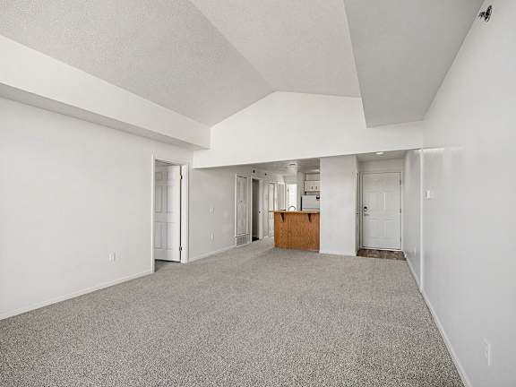 A spacious dining room with a carpeted floor and white walls  at West Hampton Park Apartment Homes, Nebraska, 68022