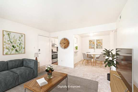 A living room leading to the dining area and kitchen at West Wind Apartments in Fort Wayne, IN