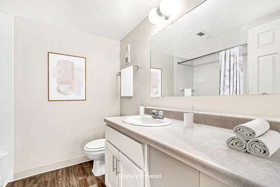 A bathroom with a toilet, sink, and mirror A bathroom with a toilet, sink, and mirror at West Wind Apartments, Indiana, 46808
