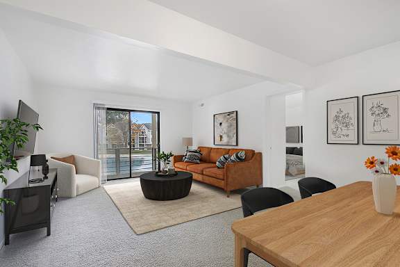A living room with a brown sofa and a wooden table.