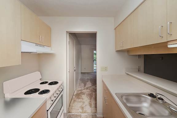 A kitchen with a white electric stove top oven at Wood Creek Apartments in Kenosha, WI