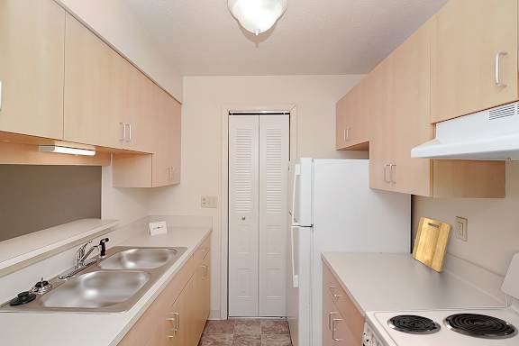 A kitchen with a pantry and an electric stove at Wood Creek Apartments in Kenosha, WI